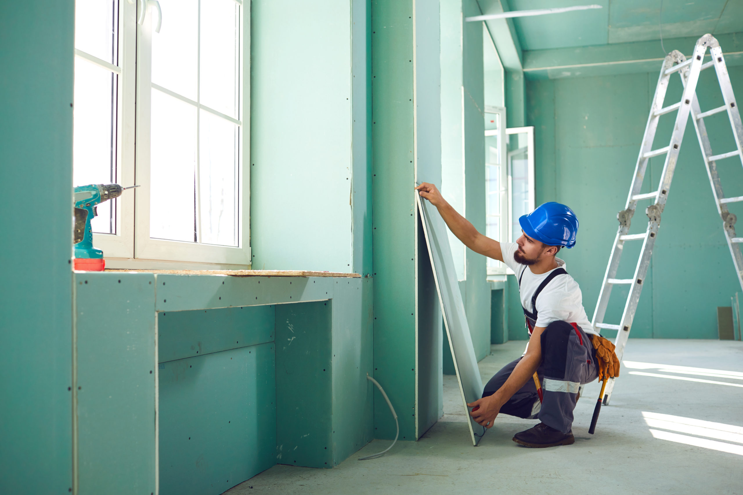 a worker in blue hardhat doing home renovation